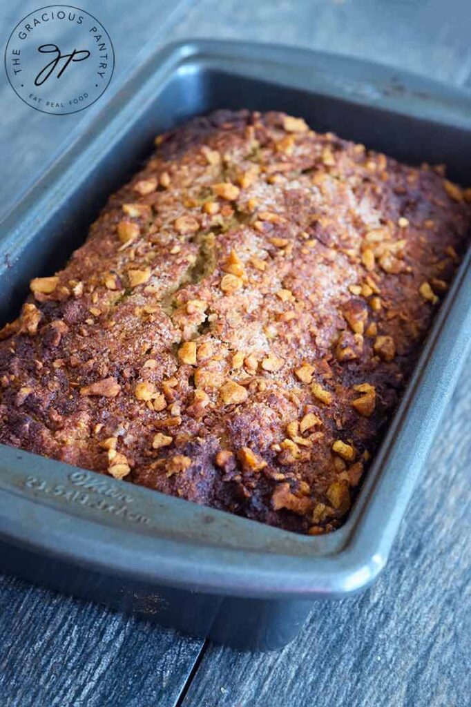 A healthy apple bread loaf still in the loaf pan.