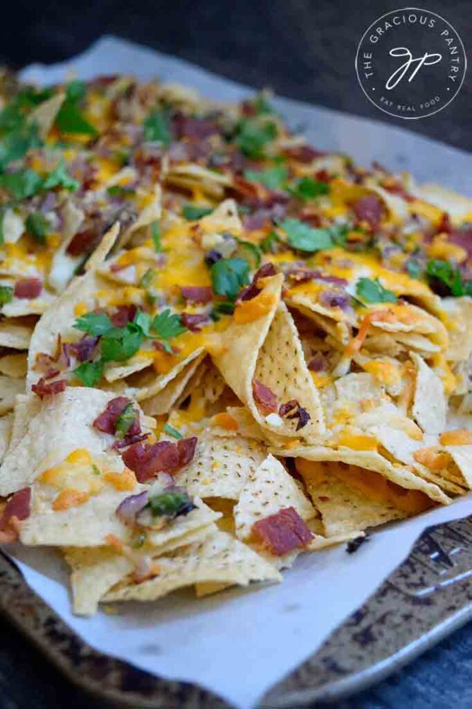 A side view of a full sheetpan of bacon jalapeno nachos.