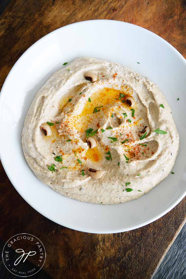 Overhead shot of a serving bowl with Black Eyed Pea Hummus being served at the table.