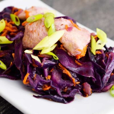 Chicken And Cabbage sits on a white, rectangular plate, ready to serve.