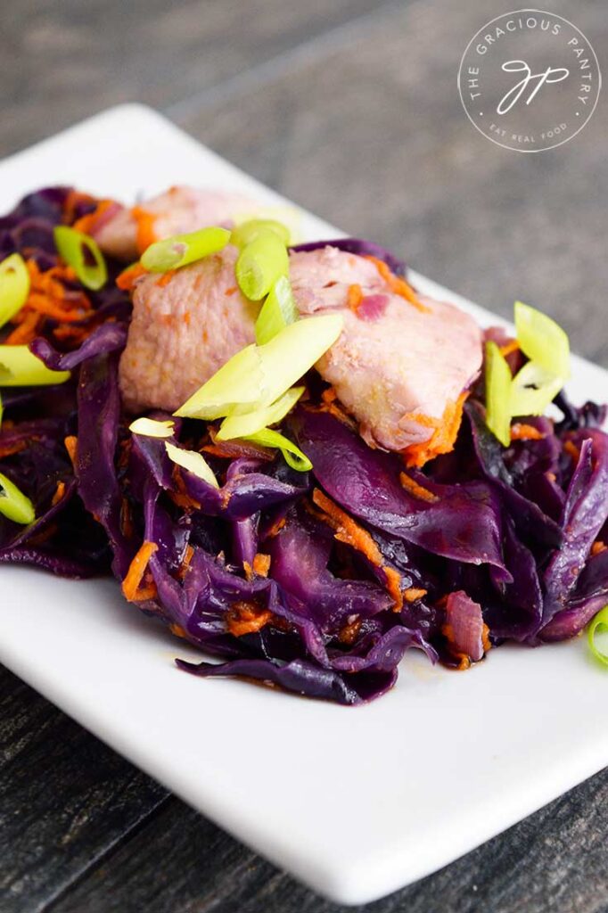 Chicken And Cabbage sits on a white, rectangular plate, ready to serve.