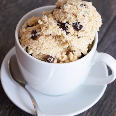 Scoops of this Edible Cookie Dough in a tea cup with a saucer and small spoon.