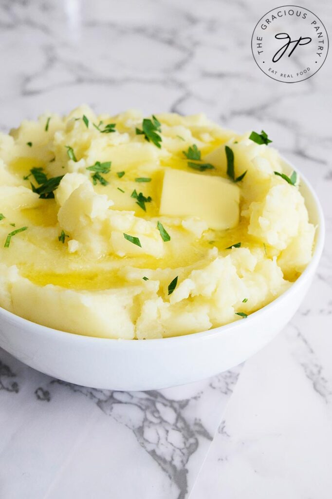 A side view of of Instant Pot mashed potatoes with melted butter on them.