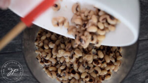 Adding black eyed peas to food processor.