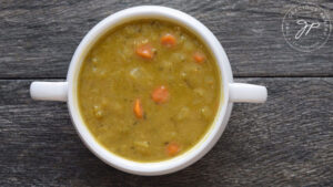 Split pea soup in a white bowl, ready to eat.