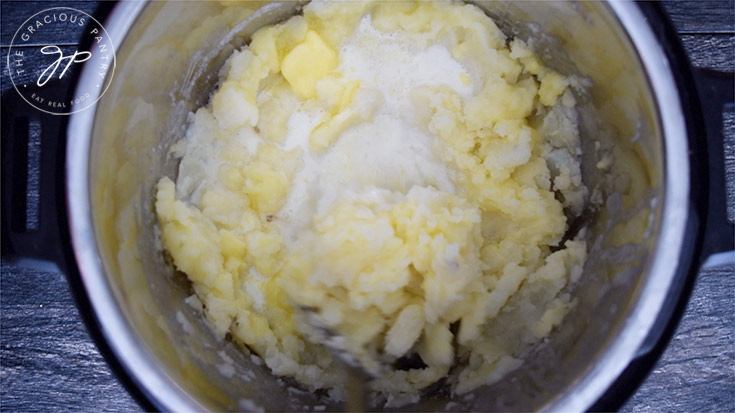 Adding milk to the mashed potatoes.