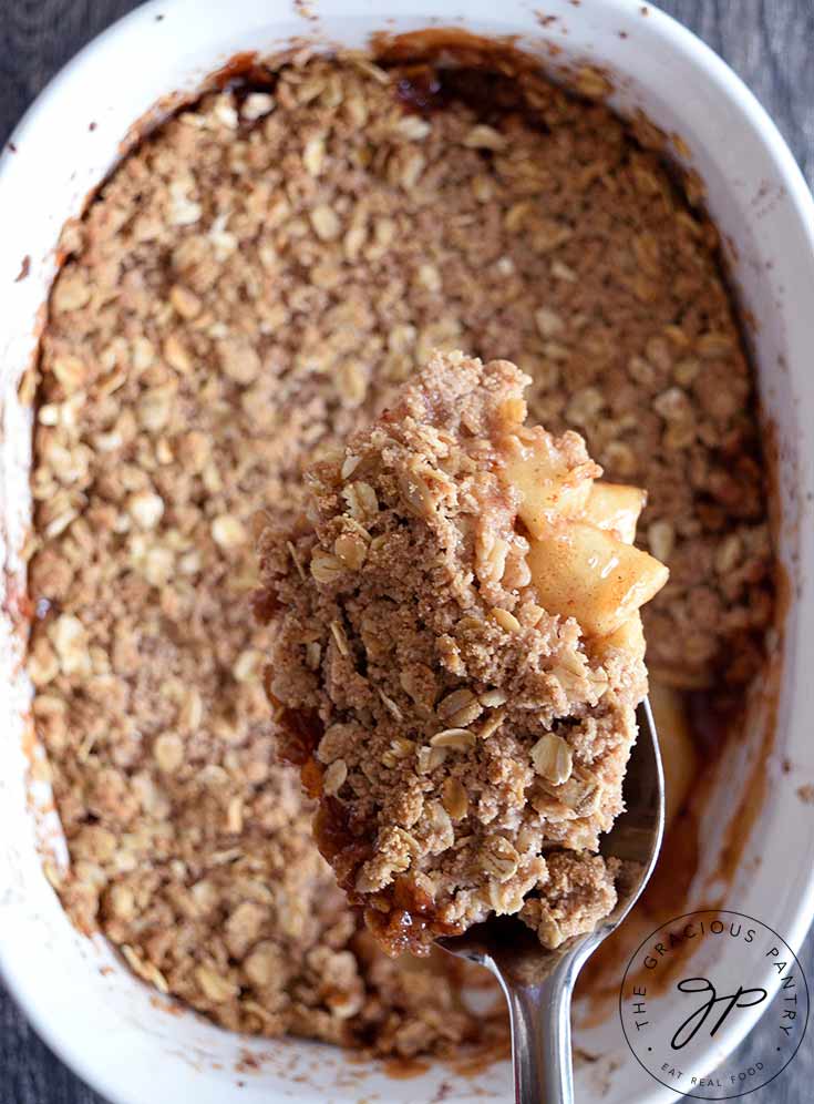A scoop of apple crisp on a serving spoon.