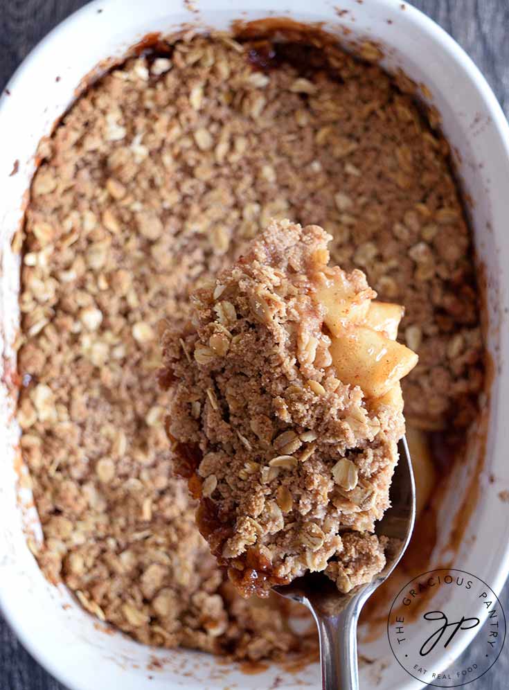 A scoop of apple crisp on a serving spoon.