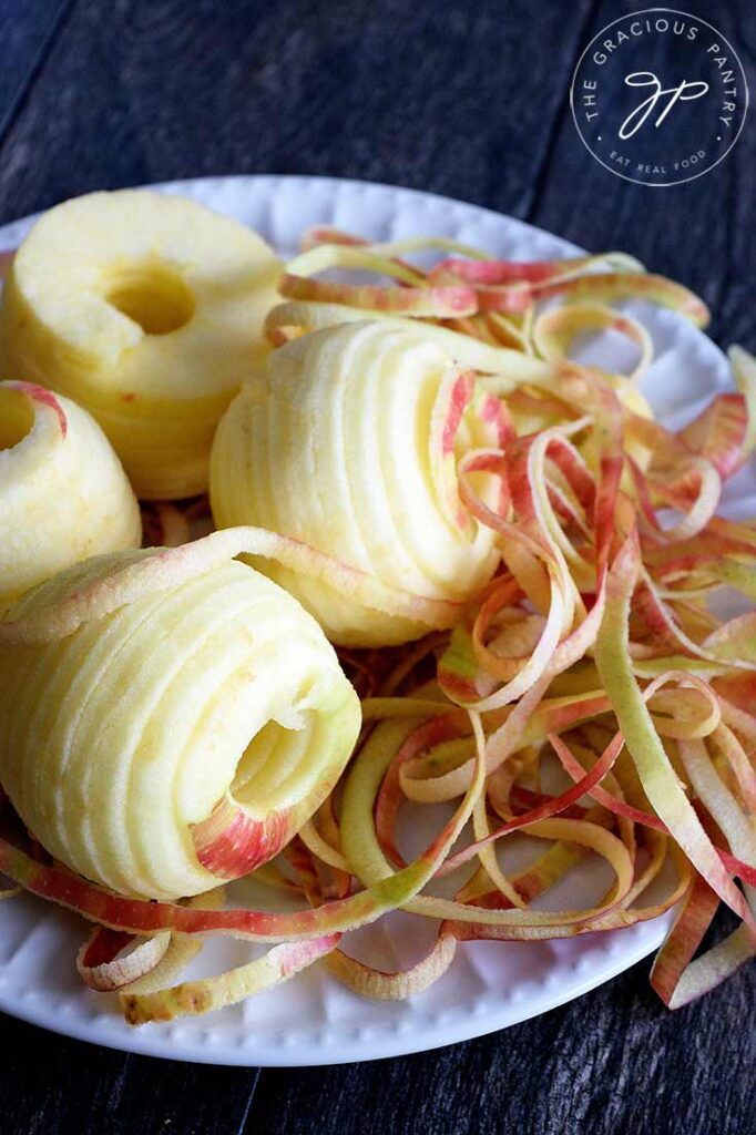 Apples peeled, cored and sliced, sitting on a plate waiting to be used in this apple crisp.