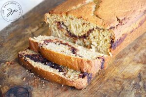 Horizontal shot of a loaf of cinnamon bread with two slices cut.