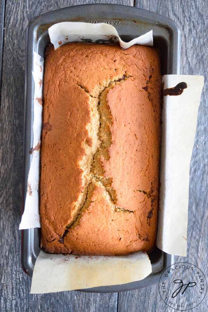 Cinnamon bread loaf in a parchment lined loaf pan.