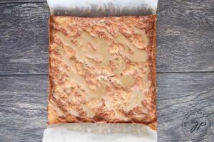 An overhead view of the uncut coffee cake with a fresh batch of glaze drizzled over the top.