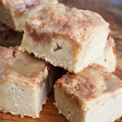 A stack of cut coffee cake with glaze on it.