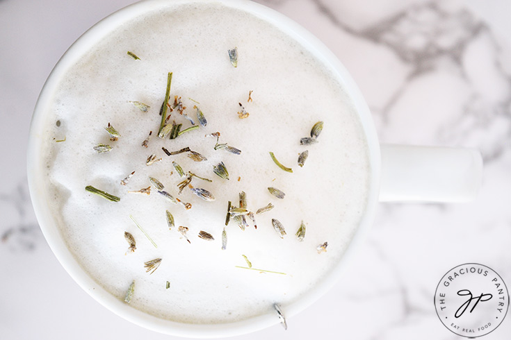 And overhead view looking down on a London Fog in a white mug, with dried lavender leaves sprinkled on top of the milk foam.
