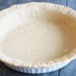 A front view of this Oat Flour Pie Crust in a white pie pan.