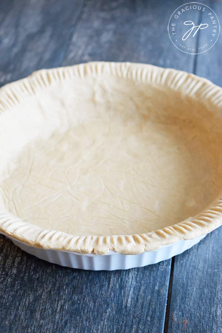 A front view of this Oat Flour Pie Crust in a white pie pan.