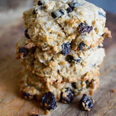 Oatmeal Raisin Cookies stacked up on a cutting board.