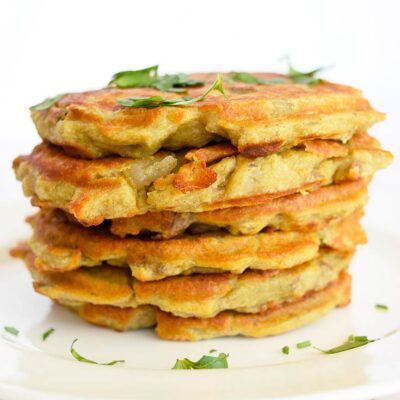 A stack of these potato pancakes sit stacked on a white plate.