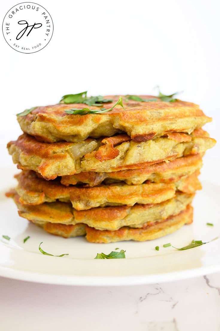 A stack of these potato pancakes sit stacked on a white plate.