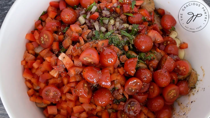 The dressing poured into the bowl of pasta.