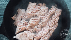 Ground meat added to skillet.