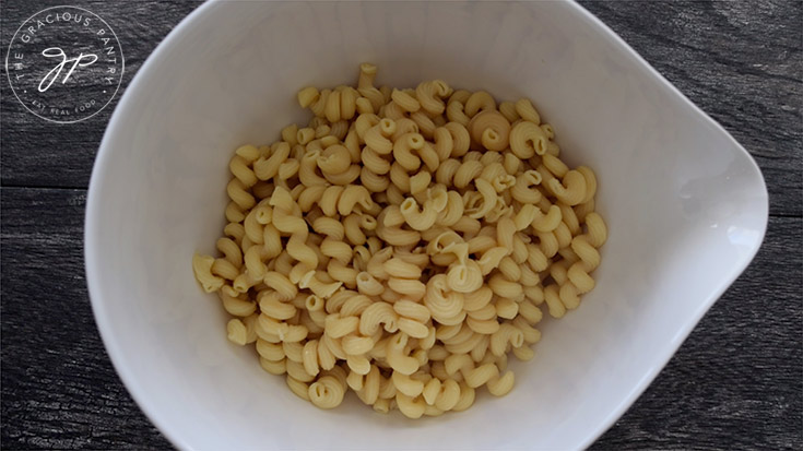 Cooked Cavatappi pasta in a large white mixing bowl.