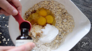 Adding vanilla to the mixing bowl.