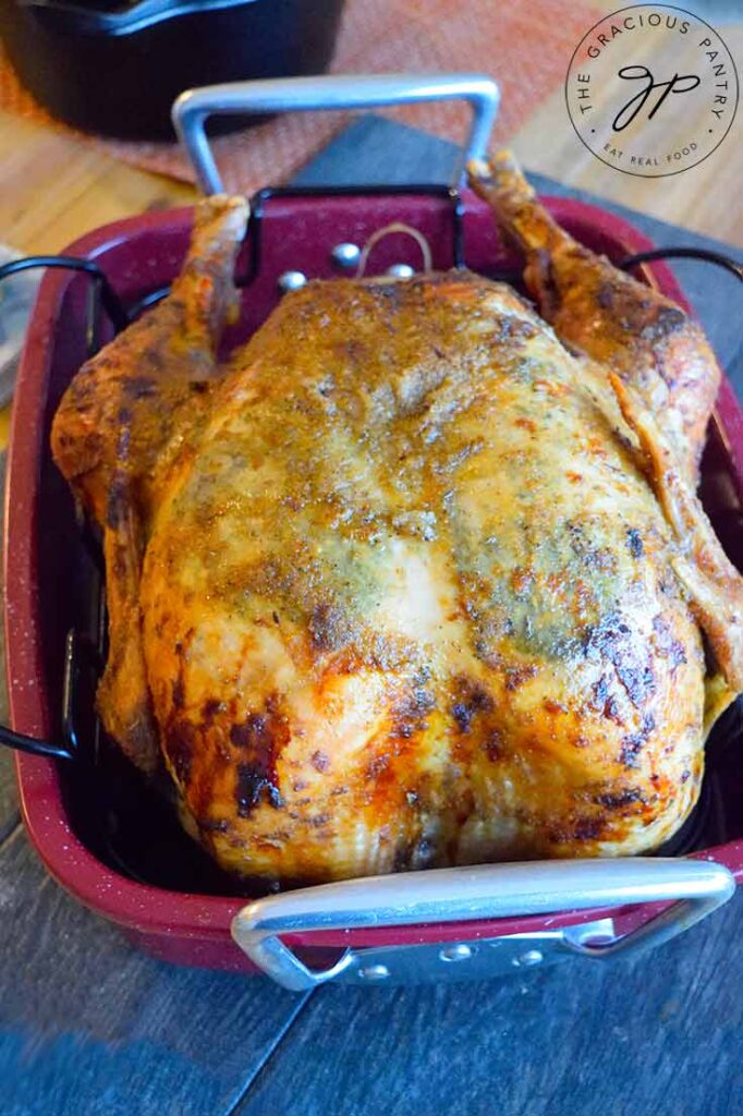 The Thanksgiving Turkey still in it's roasting pan, sitting on a table, ready to be carved.