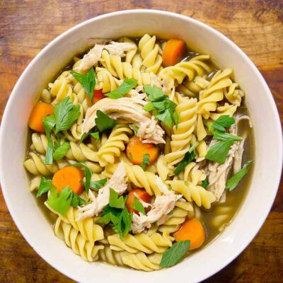 An overhead view looking down into a white bowl filled with this turkey soup recipe.