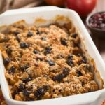 A white casserole dish sits on a table filled with a baked oatmeal recipe.