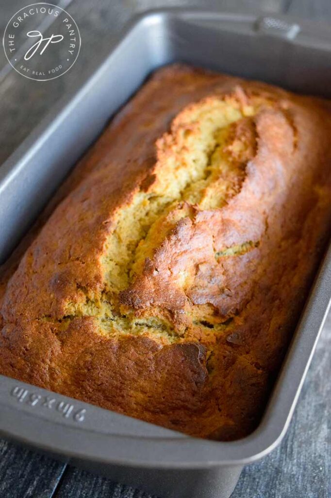 A just baked loaf of Oat Flour Banana Bread sits cooling in its loaf pan.