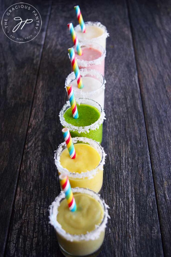 A row of Coconut Milk Smoothies in different flavors, lined up in shot glasses.