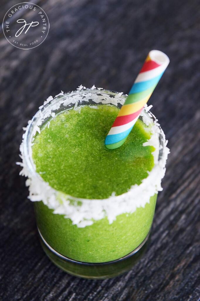 A Coconut Milk Smoothie with spinach blended in, in a shot glass, ready to drink.