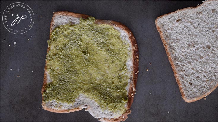 Pesto smeared on a slice of flatted bread. Pesto is optional in this recipe.