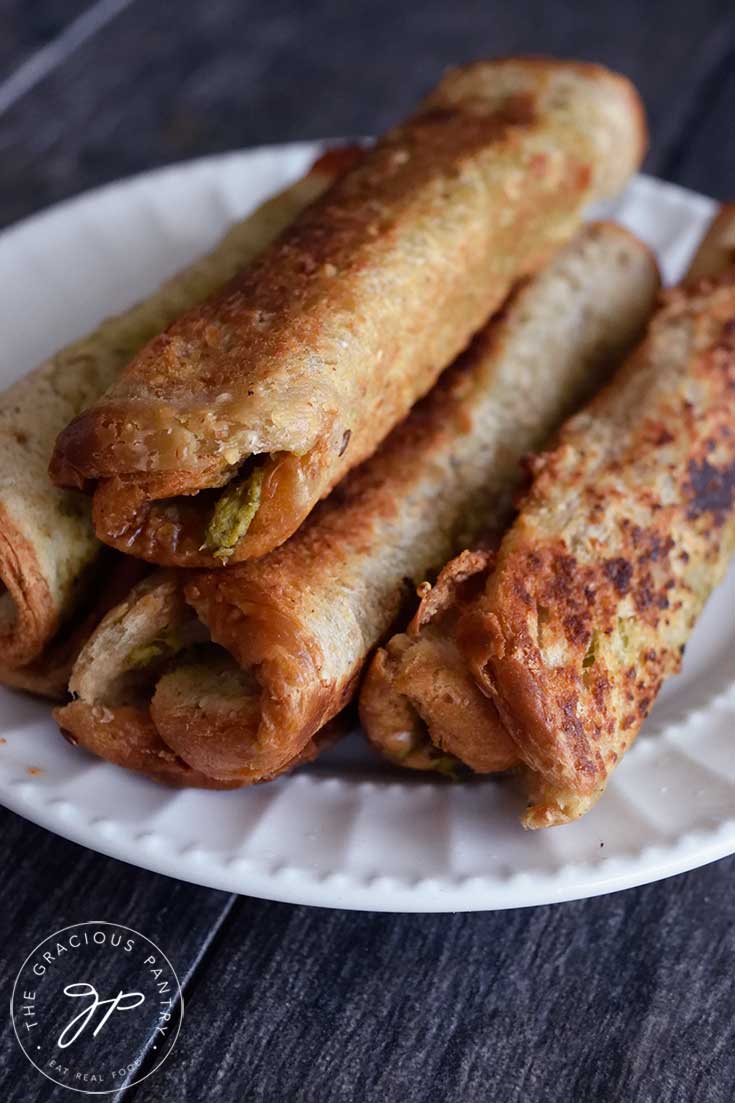 Several Grilled Cheese Roll Ups With Pesto on a serving plate.