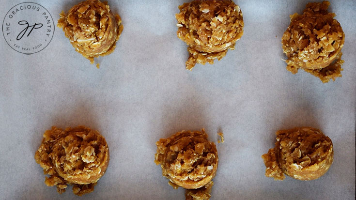 Scoops of Peanut Butter Oatmeal Cookie dough on a cookie sheet.