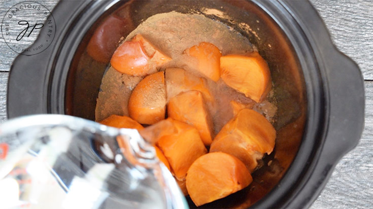The persimmons, cinnamon and water in the slow cooker, ready to cook.