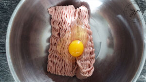 Adding an egg to the turkey.