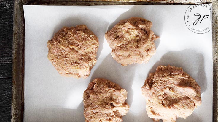 Baked Turkey Burger patties on a parchment lined cookie sheet, ready for the oven.