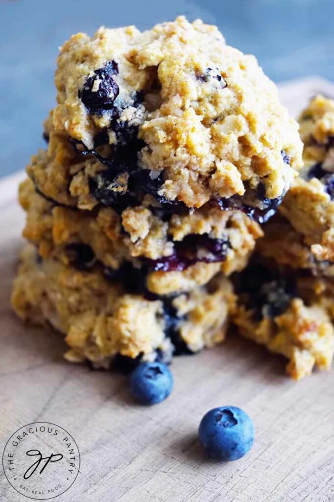 Two stacks of breakfast cookies on a cutting board with fresh blueberries scattered around the cookies. This breakfast cookies recipe comes together fast and easy! Give it a try!