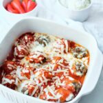 Finished Cheesy Baked Meatballs just out of the oven and still in a white casserole dish.