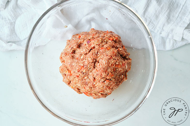 The kneaded meat mixture in a neat ball in a mixing bowl.