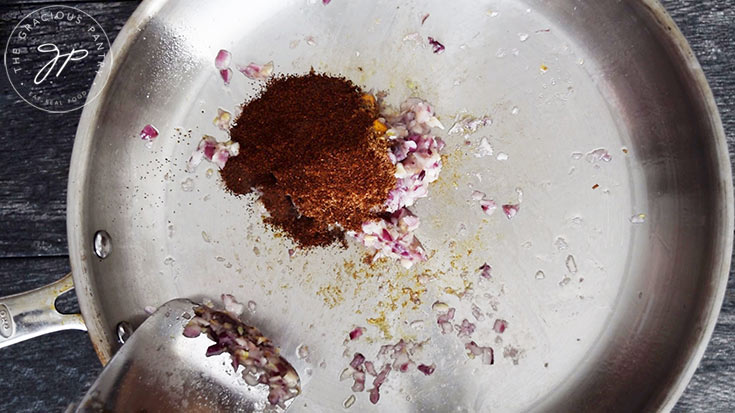 Adding the spices to the skillet.