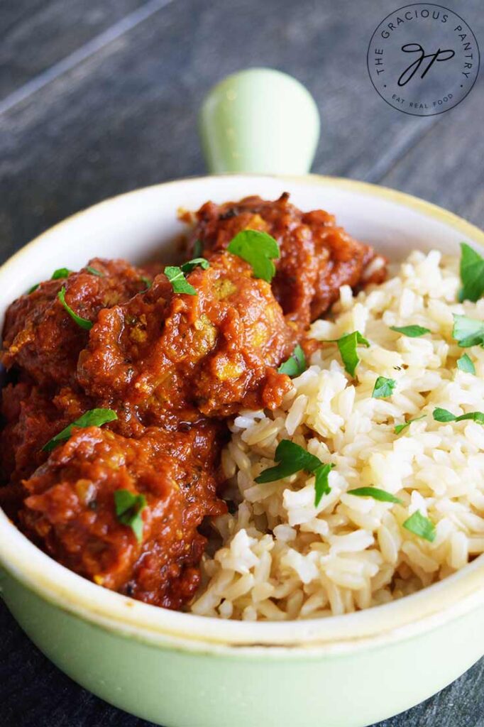 Kofta Curry Recipe in a light green crock, served with a side of brown rice.