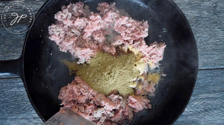 Adding spices to the ground turkey.