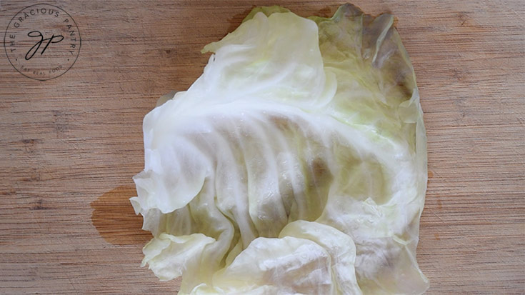 Laying out a single cabbage leaf on a work surface.