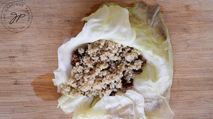 Stuffing the cabbage leaf with taco meat and quinoa.