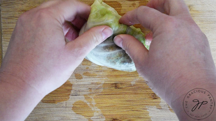 Rolling up the stuffed cabbage leaf.