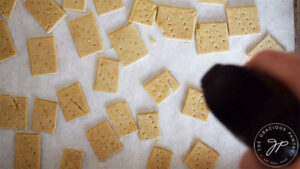 Spritzing the raw oat crackers with a light coat of oil just before they go into the oven.