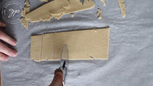 Cutting the rolled oat crackers dough into the shape of crackers.